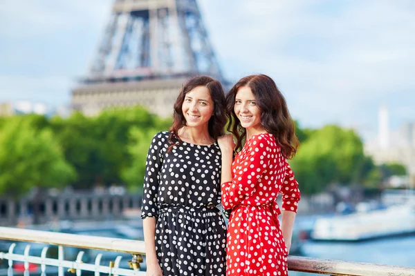 Beautiful twin sisters in front of the Eiffel tower — Stock Photo, Image