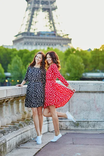Vackra tvillingsystrar framför Eiffeltornet i Paris — Stockfoto