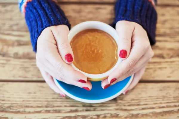 Mani donna con manicure rossa e tazza di caffè — Foto Stock