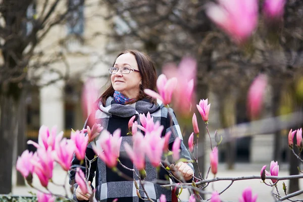 Mooie midden leeftijd bewonderende roze magnolia — Stockfoto