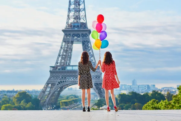 Beautiful twin sisters with colorful balloons — Stock Photo, Image