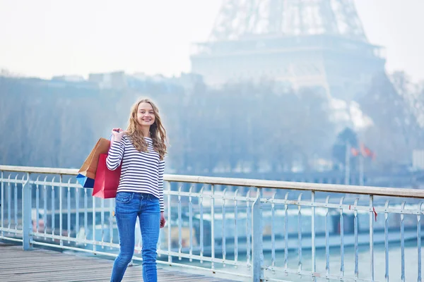 Young girl with shopping bags near the Eiffel tower — Stock Photo, Image