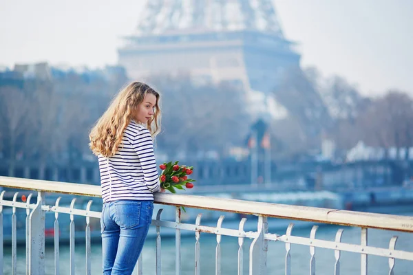 Chica con manojo de tulipanes rojos cerca de la torre Eiffel —  Fotos de Stock