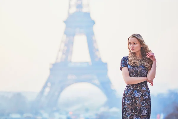 Parisian woman near the Eiffel tower at morning — Stock Photo, Image