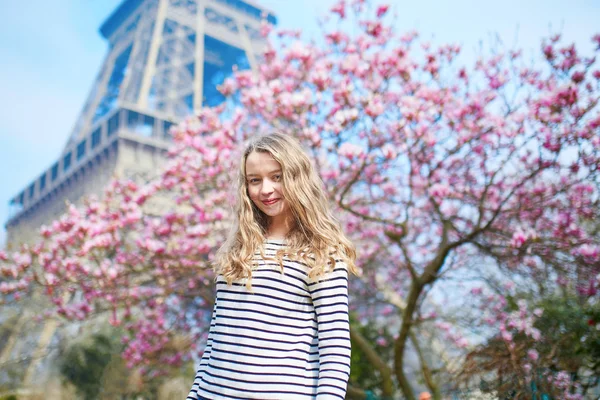 Girl in Paris near the Eiffel tower and pink magnolia — Stock Photo, Image