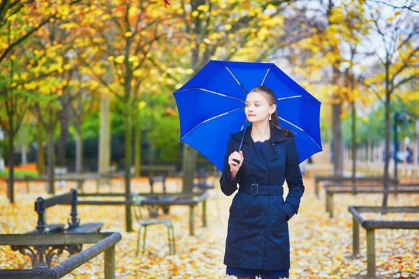 Jovem mulher com guarda-chuva azul no jardim luxemburguês de Paris em um dia chuvoso de outono ou primavera — Fotografia de Stock