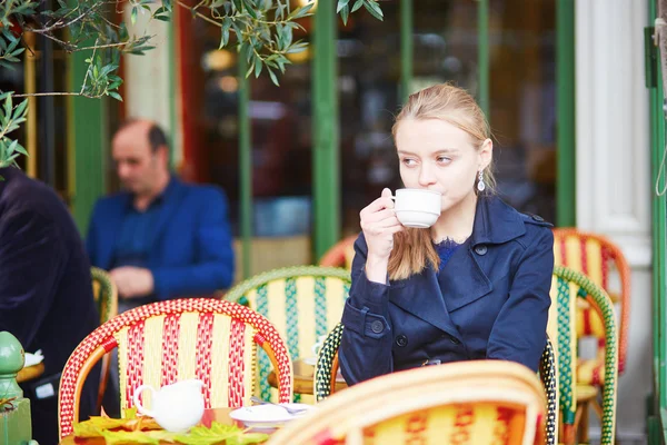 Hermosa joven bebiendo chocolate caliente en la cafetería al aire libre parisina —  Fotos de Stock