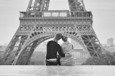 Young romantic couple near the Eiffel tower in Paris clipart