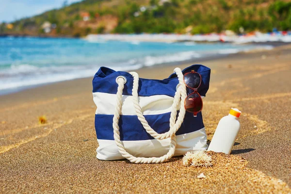 Bolsa de praia, chinelos, protetor solar e óculos de sol — Fotografia de Stock