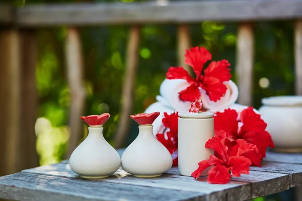 Spa omgeving met handdoeken en rode hibiscus bloemen — Stockfoto