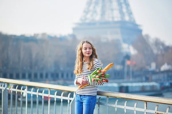 Chica con baguette tradicional francesa y tulipanes — Foto de Stock