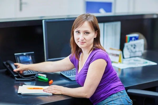 Beautiful young receptionist at work — Stock Photo, Image