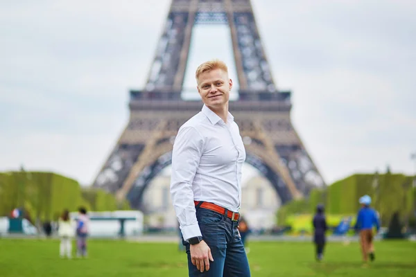 Knappe man tegenover de Eiffeltoren in Parijs, Frankrijk — Stockfoto