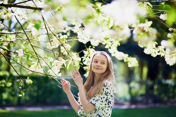 Vacker ung kvinna i blommande våren park — Stockfoto