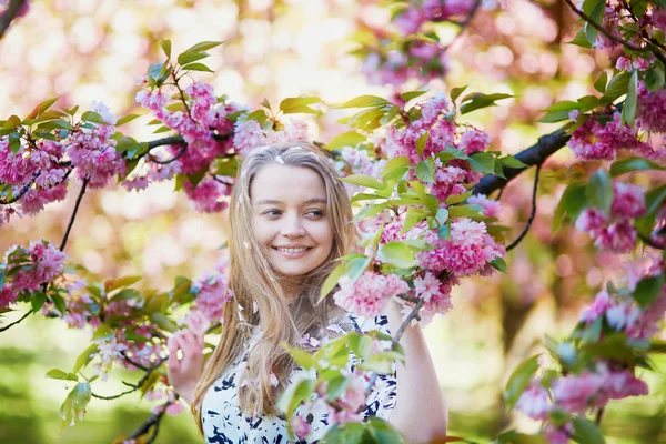 Schöne junge Frau im blühenden Frühlingspark — Stockfoto