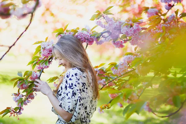 Beautiful young woman in blooming spring park — Stock Photo, Image
