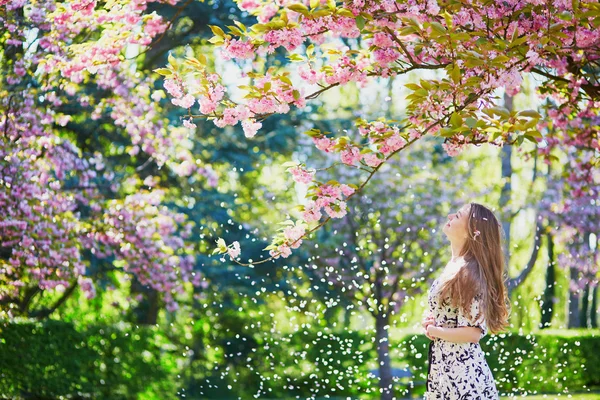 Beautiful young woman in blooming spring park — Stock Photo, Image