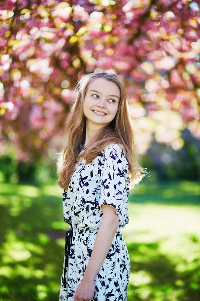 Beautiful young woman in blooming spring park — Stock Photo, Image