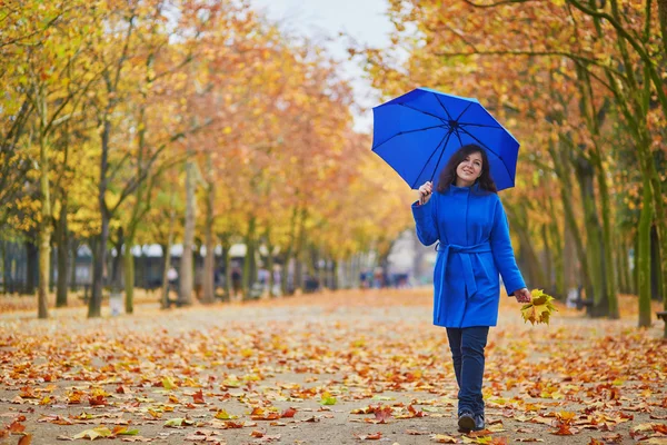 Schöne junge Frau mit blauem Regenschirm — Stockfoto