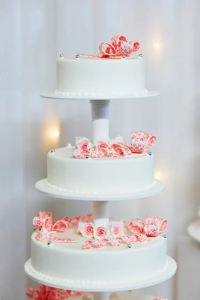 Bröllopstårta dekorerad med rosa socker band — Stockfoto