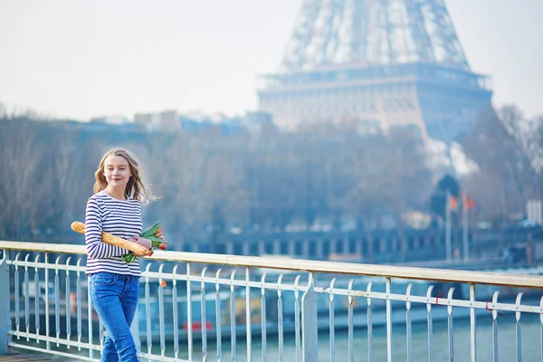 Chica con baguette tradicional francesa y tulipanes — Foto de Stock