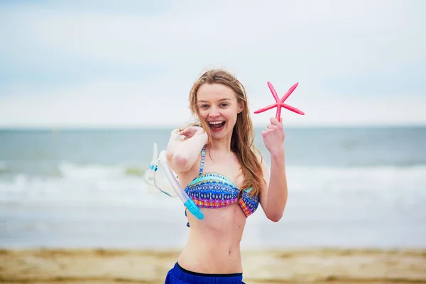 Jovem feliz de biquíni com equipamento de snorkelling e estrela-do-mar rosa — Fotografia de Stock
