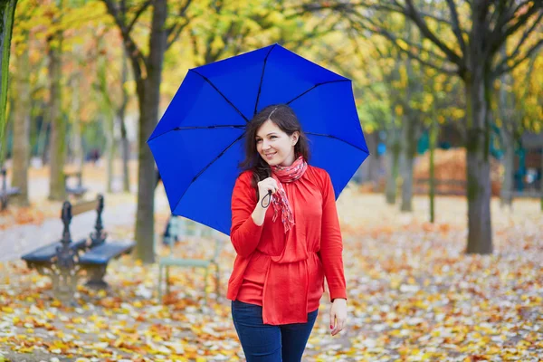Schöne junge Frau mit blauem Regenschirm — Stockfoto