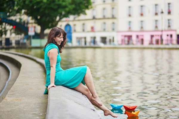 Kvinna som spelar med färgglada papper båtar på Canal Saint Martin i Paris — Stockfoto