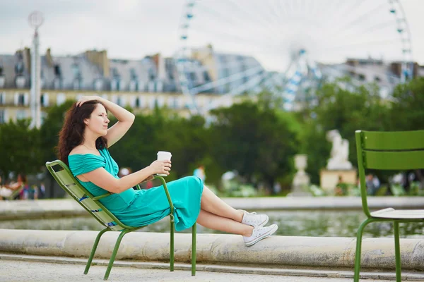 Mujer en vestido verde bebiendo café en el jardín de las Tullerías de París, Francia — Foto de Stock
