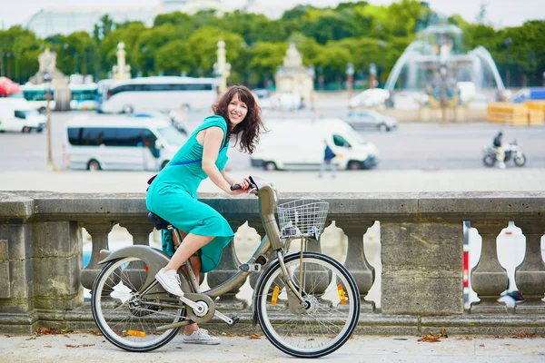 Vacker ung kvinna som rider en cykel på en gata i Paris — Stockfoto