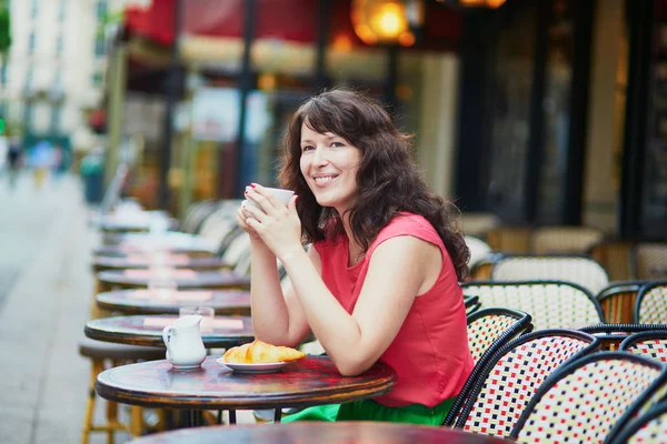 Vrouw koffie drinken en eten croissant — Stockfoto