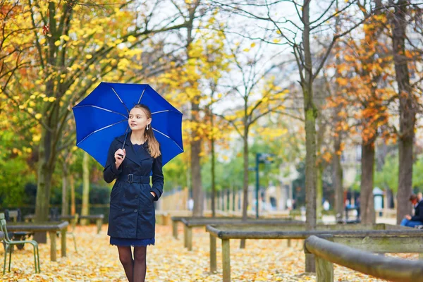 Jovem mulher com guarda-chuva azul no jardim luxemburguês de Paris em um dia chuvoso de outono ou primavera — Fotografia de Stock