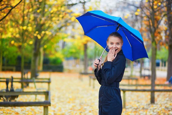 Jovem mulher com guarda-chuva azul no jardim luxemburguês de Paris em um dia chuvoso de outono ou primavera — Fotografia de Stock
