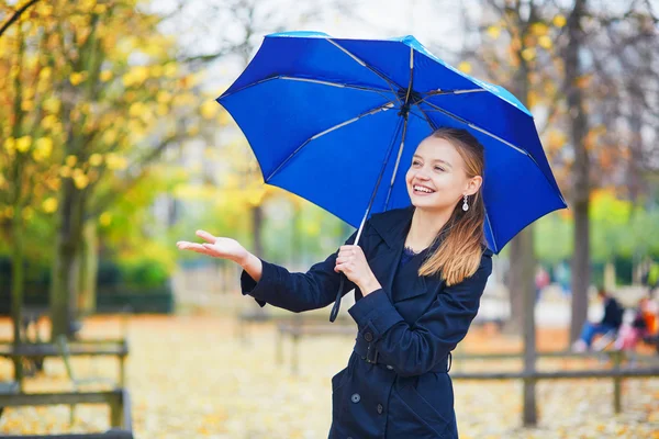 Mujer joven con paraguas azul en el jardín luxemburgués de París en un día lluvioso de otoño o primavera —  Fotos de Stock
