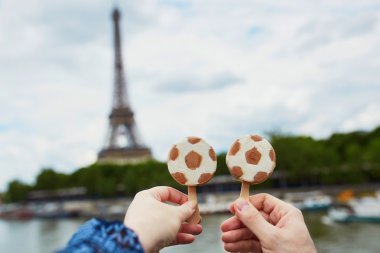 Paris'te çift Paris'te Eyfel kulesi önünde futbol topu şeklinde dondurma tutan