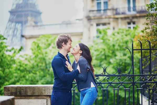 Gelukkige jonge paar voor de Eiffeltoren — Stockfoto