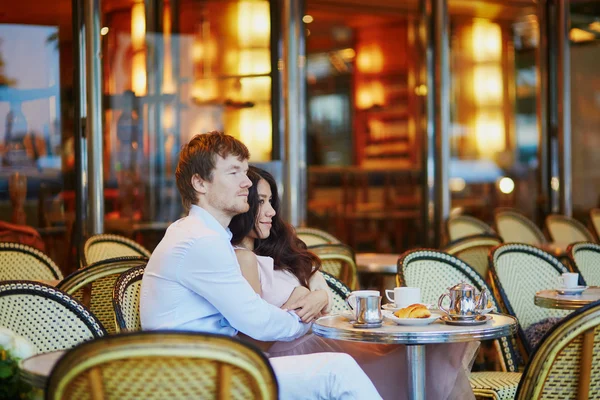 Couple drinking coffee and eating croissants in Parisian cafe — Stock Photo, Image