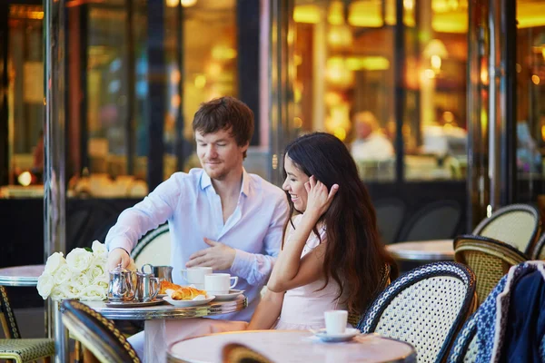 Casal beber café e comer croissants no café parisiense — Fotografia de Stock