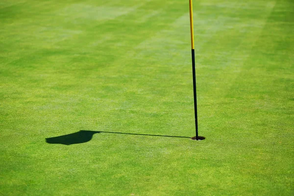 Flag shadow on golf field — Stock Photo, Image