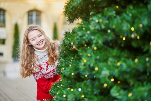 Junge Frau auf einer weihnachtlich geschmückten Straße in Paris — Stockfoto