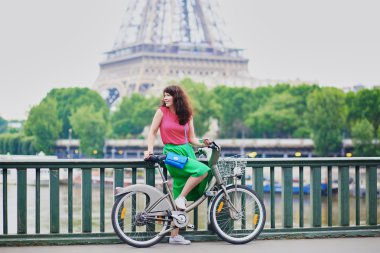 Young woman riding a bicycle on a street of Paris
