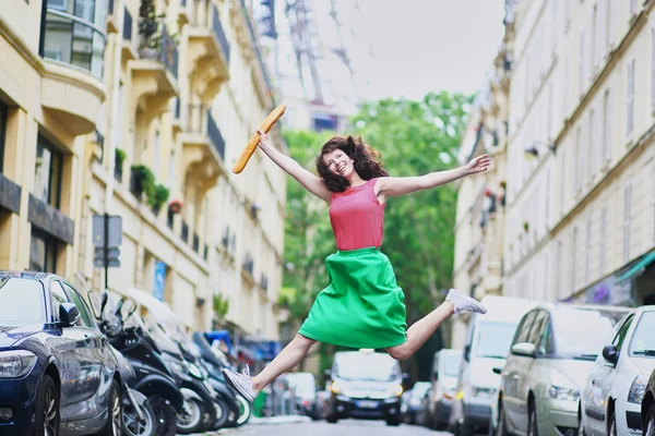 Französin läuft mit Coffee to go und Baguette und springt — Stockfoto