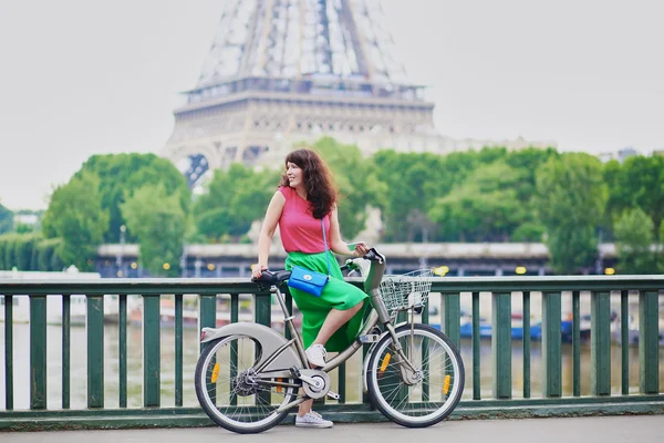 Nuori nainen ajaa polkupyörällä Pariisin kadulla — kuvapankkivalokuva