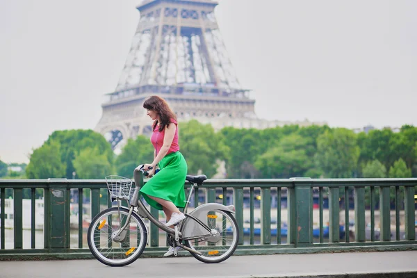 Young woman riding a bicycle on a street of Paris — Stockfoto