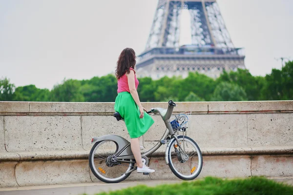 Young woman riding a bicycle on a street of Paris — Stockfoto