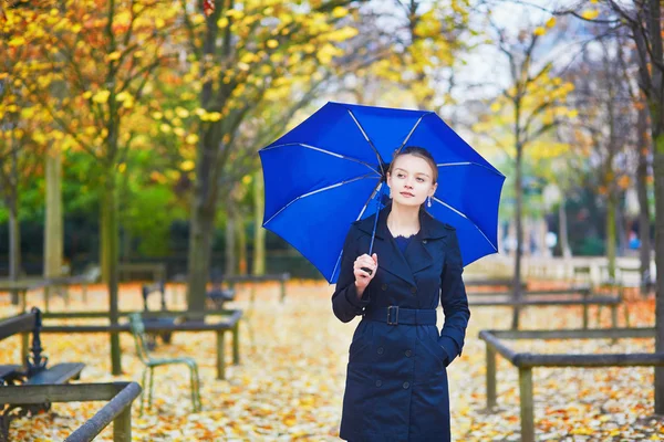 Jeune femme au parapluie bleu dans le jardin luxembourgeois de Paris un jour de pluie d'automne ou de printemps — Photo