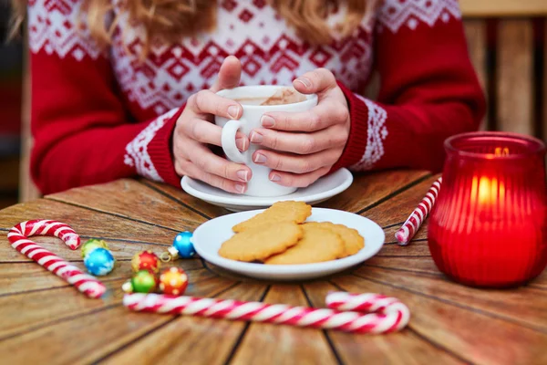 居心地の良い屋外のパリのカフェでホット チョコレートを飲んでいる女性がクリスマスの装飾 — ストック写真
