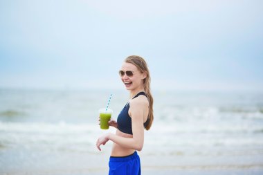 Koşucu kız içme yeşil sebze smoothie