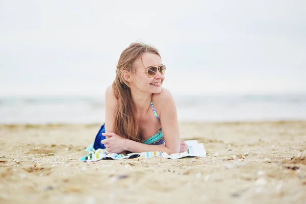 Femme relaxant et bronzant sur la plage de sable — Photo