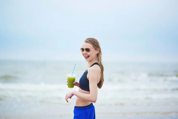 Runner menina bebendo smoothie vegetal verde — Fotografia de Stock